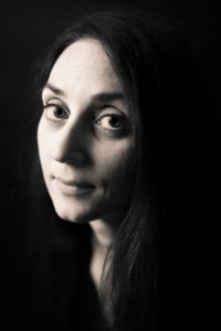 portrait femme noir et blanc fond noir effet Joconde grands yeux sourire photographe portraitiste Blois