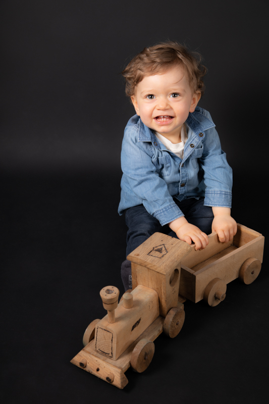 photo enfant garçon petit train en bois fond noir en couleurs portrait photographe Blois